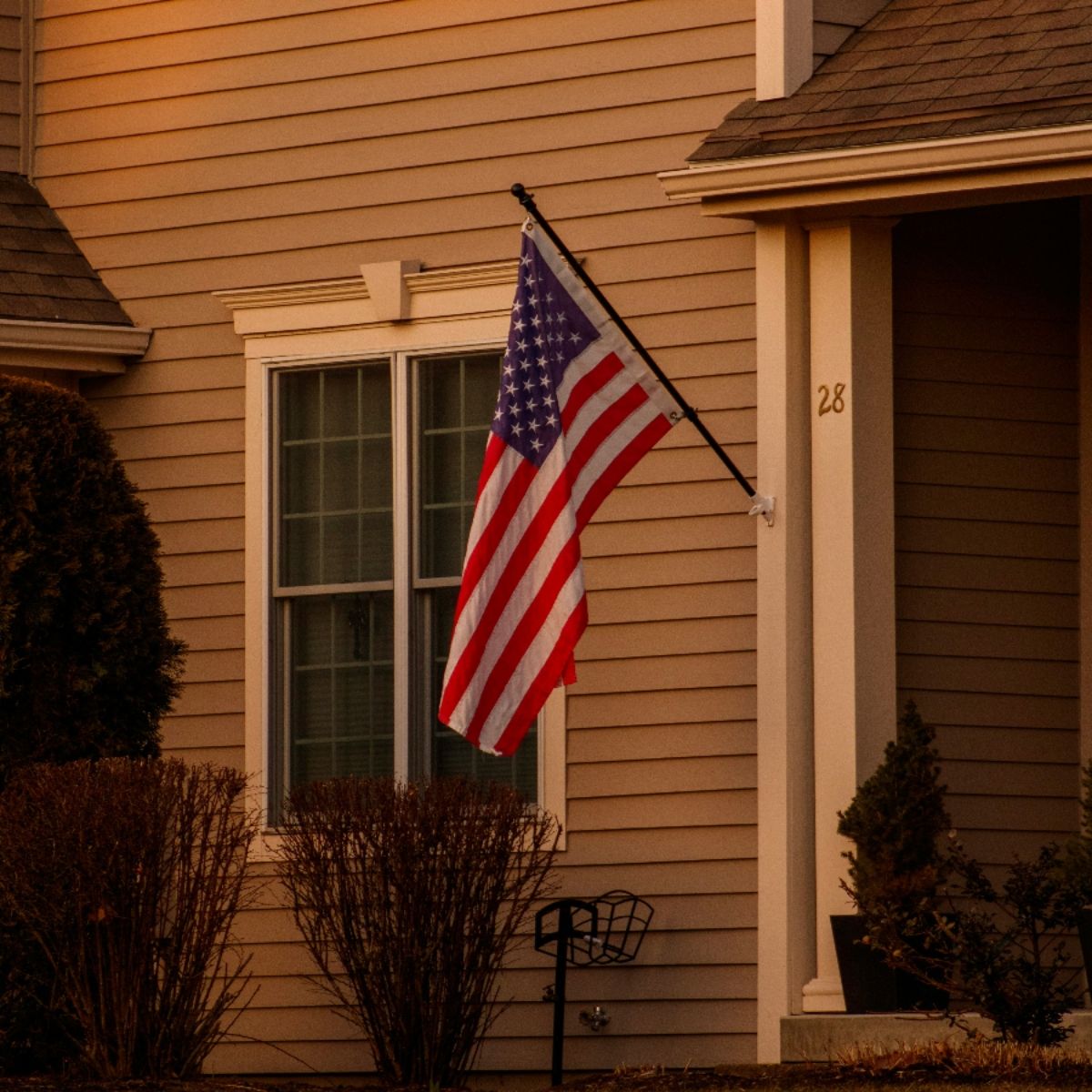 American flag outside a house at sunset.