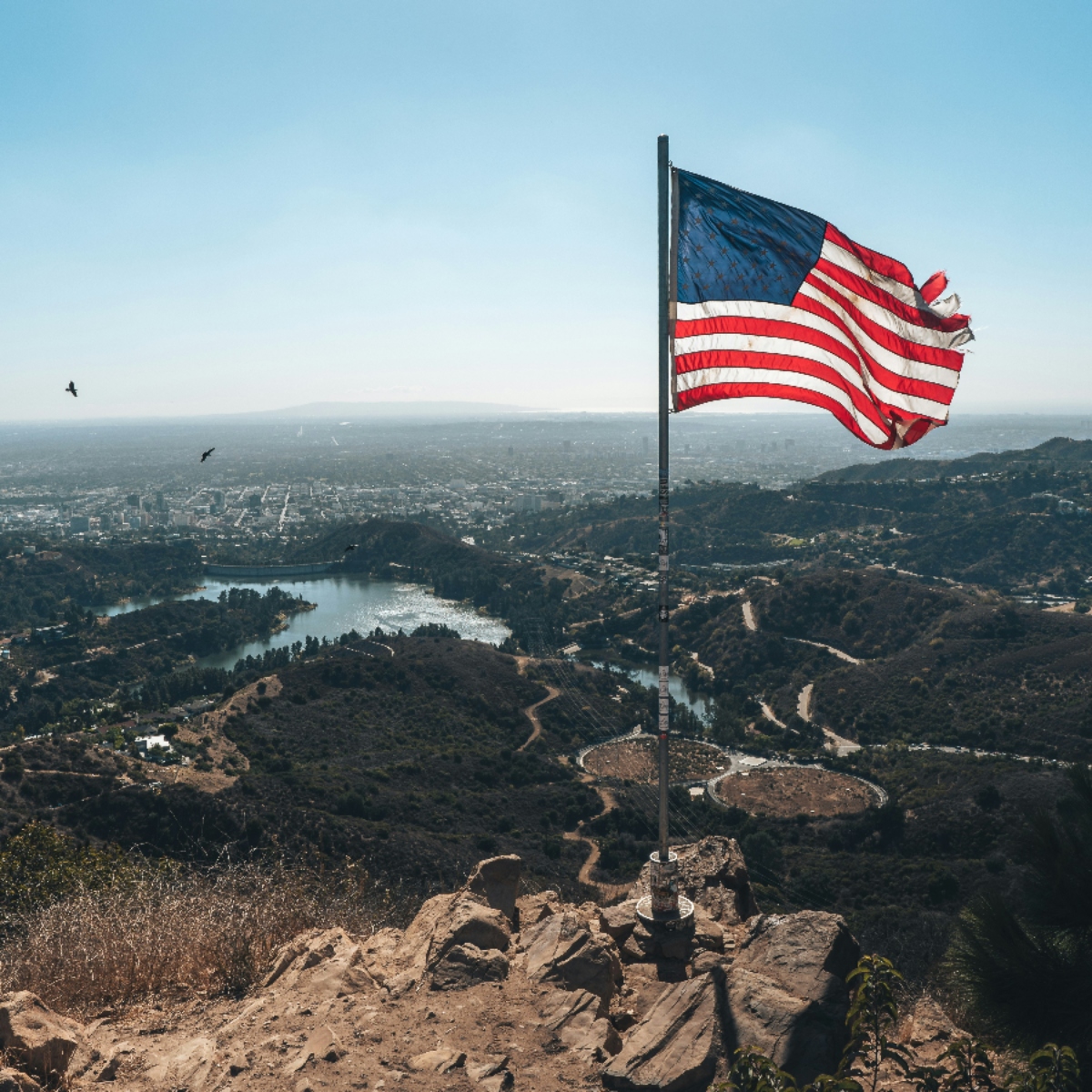 American flag flying over scenic landscape view.