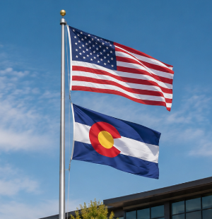 American and Colorado flags flying against blue sky