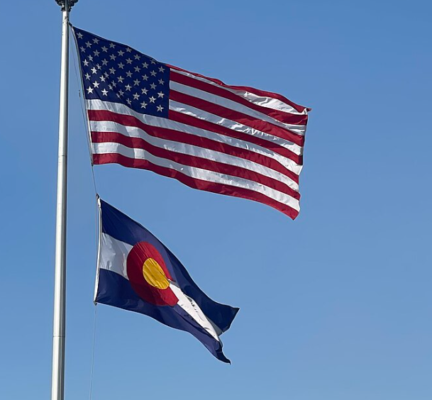 usaco U.S. and Colorado flags flying against blue sky